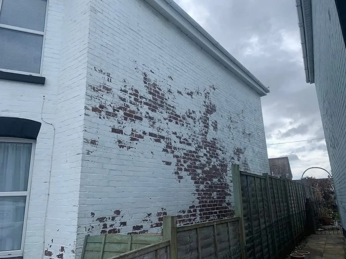 Peeling paint on a brick wall before redecoration in Gorran Haven
